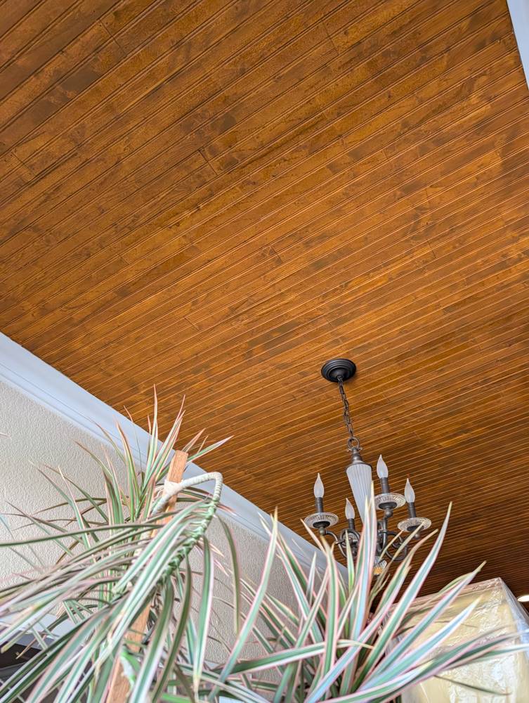 Stained beadboard ceiling with chandelier
