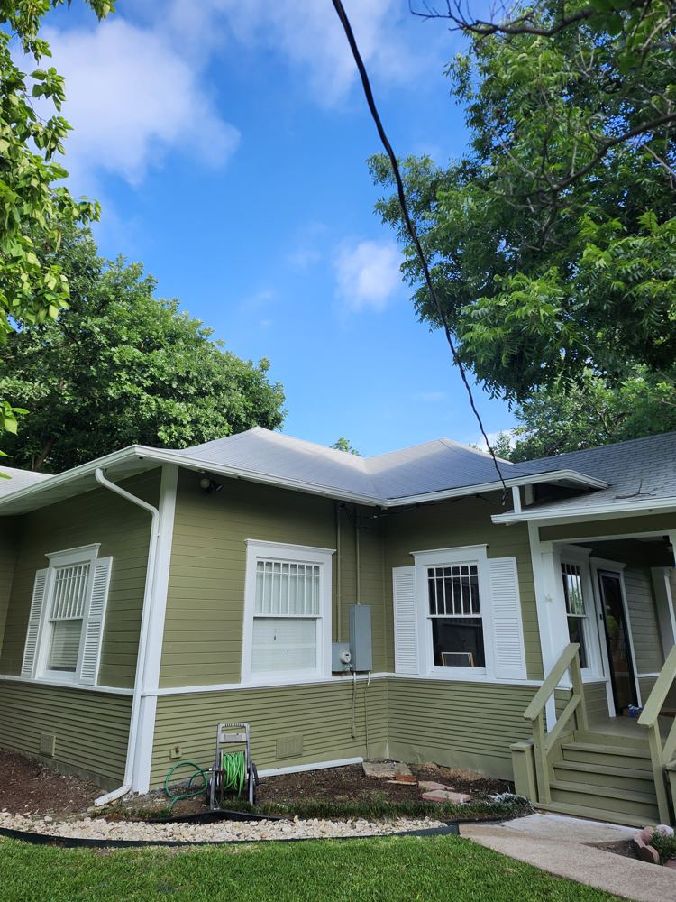 Same side of the house freshly painted green with white trim and shutters