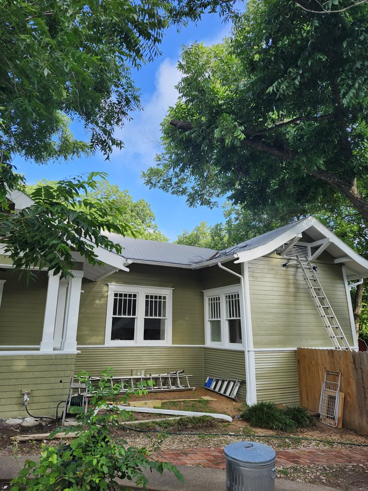 Freshly painted green house with white trim